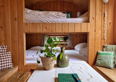 twee bedden en tafel Pipowagen De Kruiponder Boerderij de Mossel Otterlo Overnachten 2